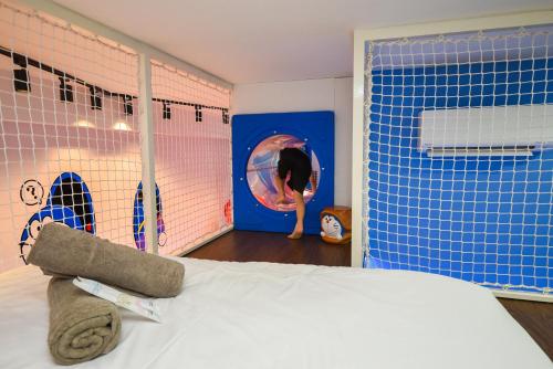 a bedroom with a bed and a dummy in a window at Sunway Grid Loft Suite by Nest Home【Olympic Size Pool】 in Kampong Pendas