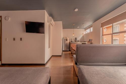 a living room with two beds and a kitchen at Soy Local Parque La 93 in Bogotá