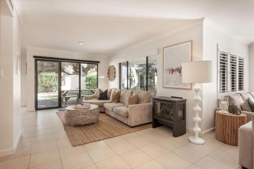 a living room with a couch and a fireplace at Sunset and Surfside in Yallingup