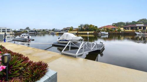 een boot is aangemeerd op een dok in het water bij Relax Poolside By The Canal in Bongaree