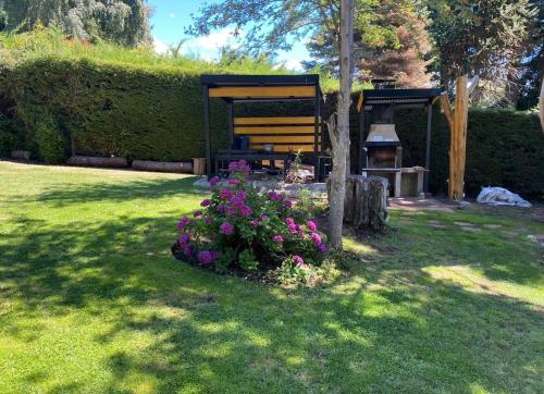 a garden with a bench and flowers in the grass at Hermosas Cabañas con vista al Nahuel Huapi in San Carlos de Bariloche