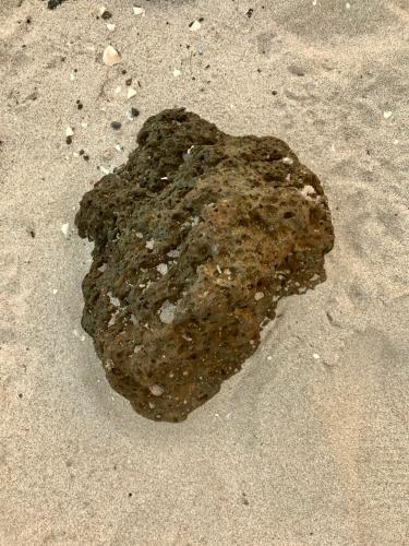 a large rock in the sand on the beach at Pyoseon Mansion in Seogwipo