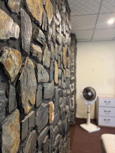 a stone wall in a room with a lamp at Northlanders Guest House Skardu in Skardu