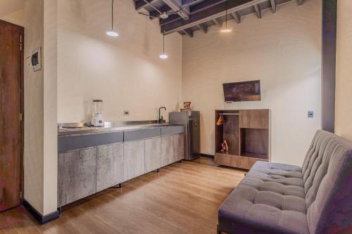 a kitchen with a couch and a counter in a room at Soy Local Parque La 93 in Bogotá