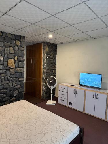 a bedroom with a bed and a stone wall at Northlanders Guest House Skardu in Skardu