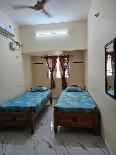 two beds in a room with two windows at ELCI Residence PG luxury womens hostel Tambaram in Chennai