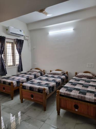 a room with three beds in a room at ELCI Residence PG luxury womens hostel Tambaram in Chennai
