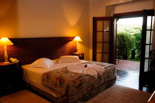 a bedroom with a large bed with a large headboard at Canto da Floresta Ecoresort in Amparo