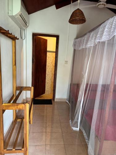 a room with a table and a chair and a door at Cozy Sand Beach Hotel in Arugam Bay