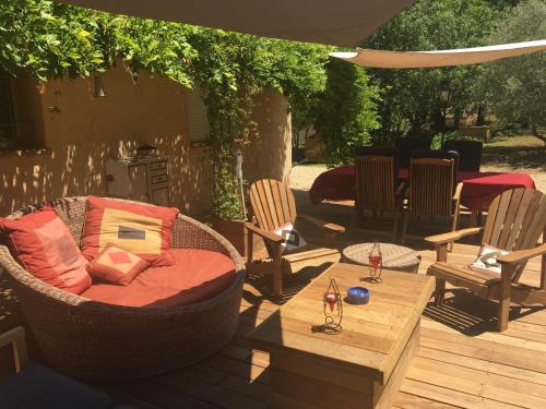 a patio with chairs and a couch and a table at Bulle d'amour in Montauroux