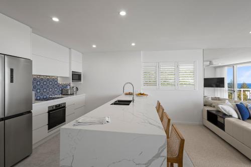 a white kitchen with a large white counter top at Sunshine Vista in Sunshine Beach