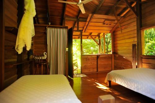 a bedroom with two beds in a wooden cabin at Suital Lodge in Mogos