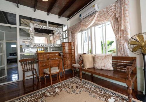 a living room with a bench and a window at RQ Timeless Dinsor Cultural Heritage House in Bangkok