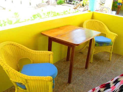 a table and chairs in a room with a yellow wall at Colinda Cabanas in Caye Caulker