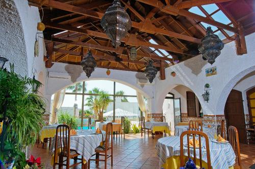 a restaurant with tables and chairs in a building at Family Agua Amarga in Agua Amarga