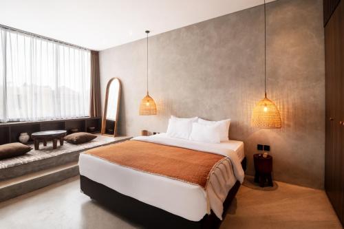 a bedroom with a large bed and two pendant lights at Balenji Villa by BaliSuperHost in Munggu