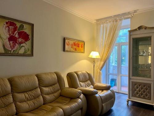 a living room with a leather couch and a window at Apartment - Independence Square in Kyiv
