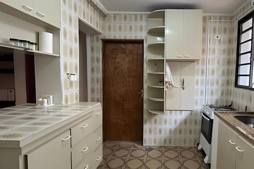 a kitchen with white cabinets and a brown door at Casa Ibirapuera - Hospedagem Domiciliar in Sao Paulo