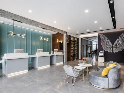 a room with a bar with a couch and chairs at GEM Hotel Changzhou Xuejia'aoyuan North High-Speed Railway Station in Changzhou