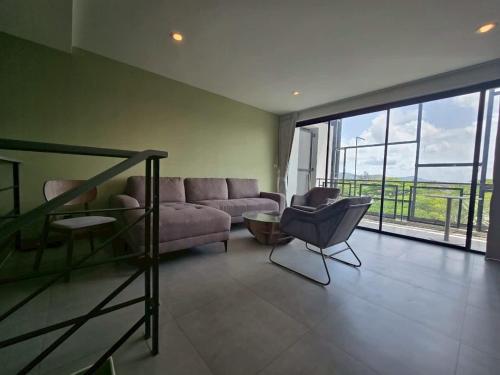 Laguna PhuketにあるLoft condo in Laguna Phuketのソファと椅子のあるリビングルーム