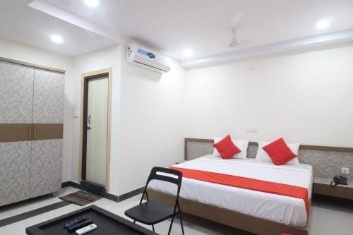 a bedroom with a large bed with red pillows at Arjuna Luxury Rooms in Hyderabad