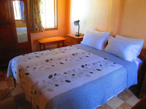 a bedroom with a bed with a blue comforter at Colinda Cabanas in Caye Caulker