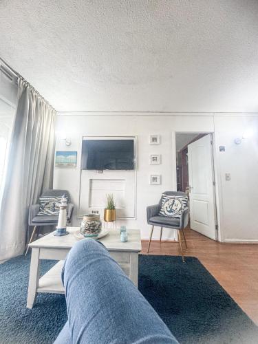 salon z kanapą i stołem w obiekcie Departamento Reñaca w mieście Viña del Mar