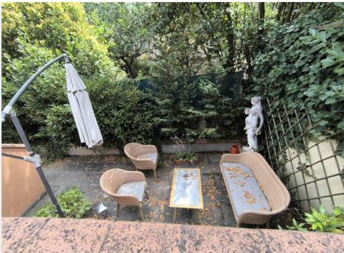 a garden with chairs and a table and an umbrella at Locanda Il Gallo in Greve in Chianti