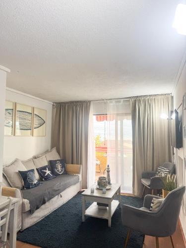 salon z kanapą i stołem w obiekcie Departamento Reñaca w mieście Viña del Mar