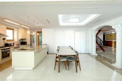 a white kitchen with a table and chairs at Le comte bleu in Pyeongchang 