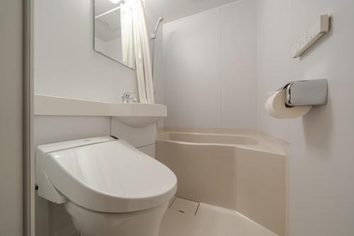 a white bathroom with a toilet and a sink at Ryokan Yamazaki in Kyoto