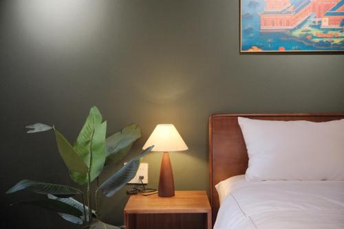 a bedroom with a bed and a lamp on a table at DAINOI Hue Homestay in Thôn Kim Long (1)