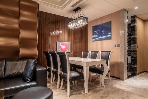a dining room with a table and leather chairs at Guide Hotel Taichung Ziyou in Taichung