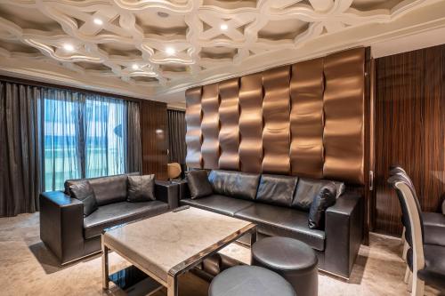 a living room with a leather couch and a table at Guide Hotel Taichung Ziyou in Taichung