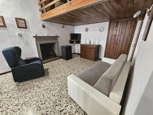 a living room with a couch and a chair and a fireplace at Dimora dei Consoli in Gubbio