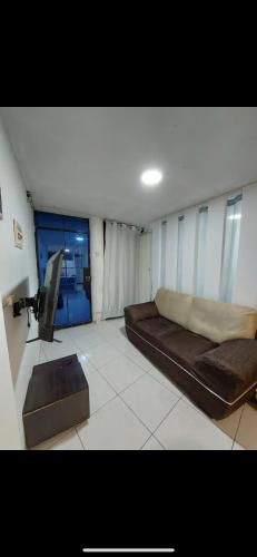 un salon avec un canapé et une télévision dans l'établissement Pequeño Departamento, à Los Blancos