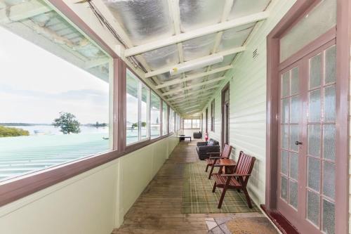 a hallway of a house with windows and chairs at The Happy Pelican Harrington Hotel in Harrington