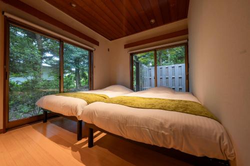 伊東市にあるソテツアンの窓が2つある部屋にベッドが2つある