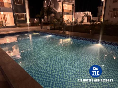 a large swimming pool with blue water at night at Le Park Luxury Resort - TIE Hotels & Resorts in Puducherry