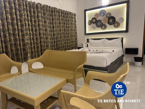 a hotel room with a bed and a table and chairs at Le Park Luxury Resort - TIE Hotels & Resorts in Puducherry
