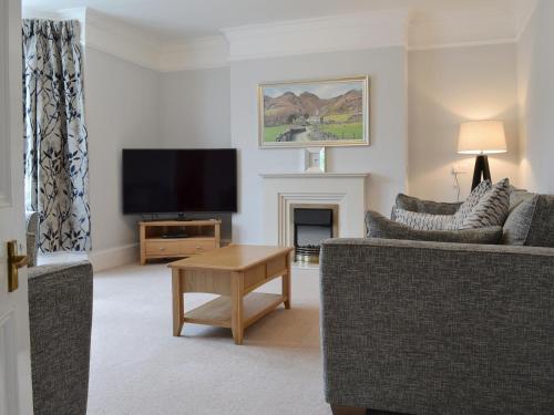 a living room with a couch and a tv at The Birches in Keswick