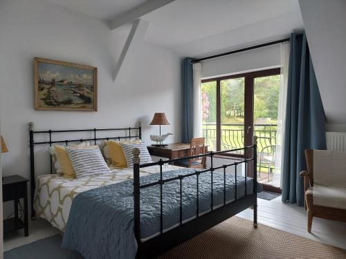 a bedroom with a bed and a sliding glass door at Tatowo in Darżlubie