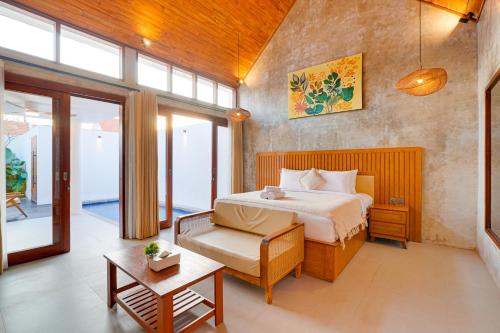 a bedroom with a bed and a couch and a table at Charming 1BR Villa Gypsophila Laluxe A16 Sanur in Sanur