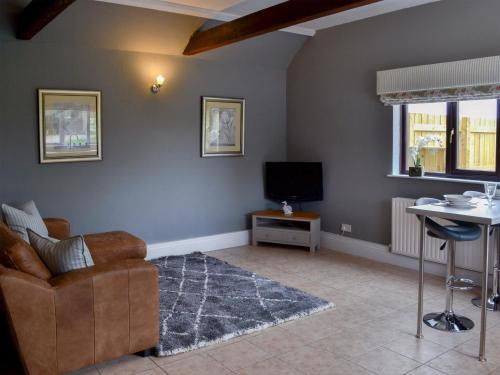 a living room with a couch and a television at Oxley Cottage in Orby