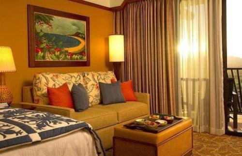a hotel room with a bed and a couch at Aulani, Disney Vacation Club Villas in Kapolei