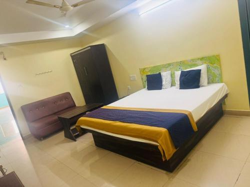 a bedroom with a large bed and a chair at Hotel O Kurnool City Railway Junction Formerly Diamond Court in Kurnool
