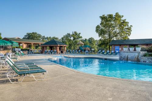 a swimming pool at a resort with chairs and tables at Westgate Branson Woods Resort in Branson
