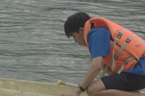 a young boy is rowing a boat in the water at Rosée De Kala - A&Q Suite in Rhang Ung (3)