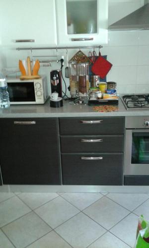 a kitchen with a stove and a microwave at La Magnolia - Fano in Fano