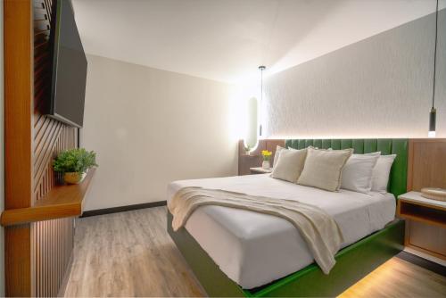 a bedroom with a white bed with a green headboard at LYFE INN & SUITES by AGA- North Hollywood Near Universal Studios in North Hollywood